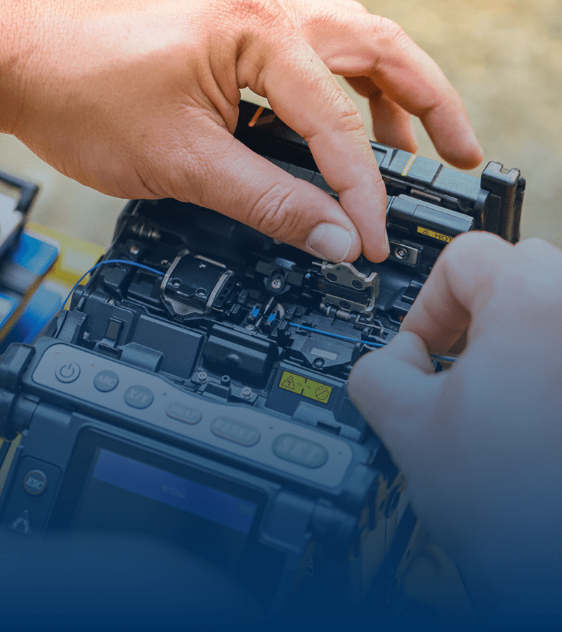 Hands repairing a complex electronic device.