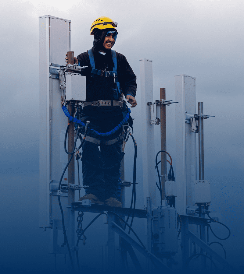 Worker on tower with safety gear.