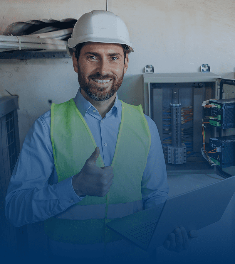 Smiling engineer giving thumbs up with laptop.