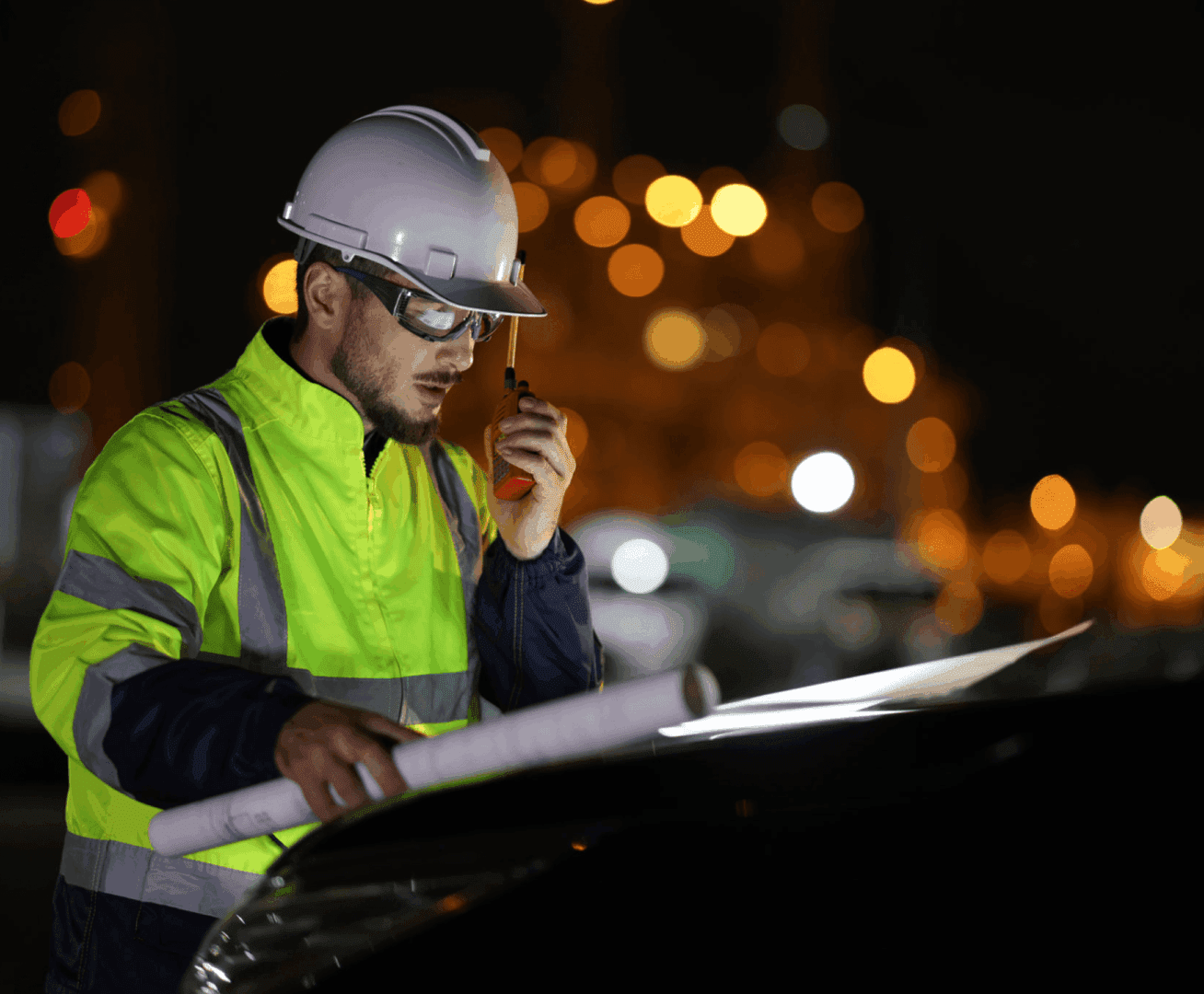 Engineer reviewing plans at construction site.
