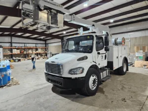 White utility truck inside a warehouse.