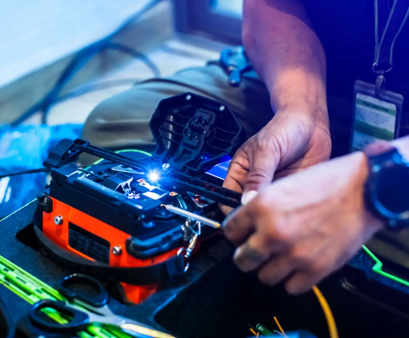 Technician working on fiber optic splicing equipment.